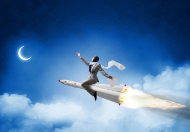 Zemin üzerine mavi gece gökyüzü bulutlar ve ay ile roket üzerinde uçan takım elbiseli genç işadamı kavramsal görüntü.