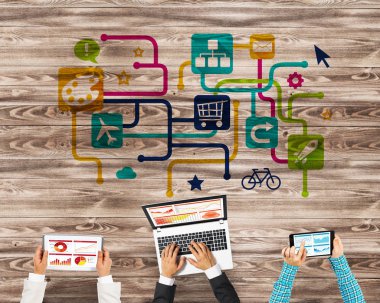 Ellerinde cihazlar bulunan üç kişilik bir grup iletişim ve ağ oluşturma sembolü olarak birlikte çalışıyor.