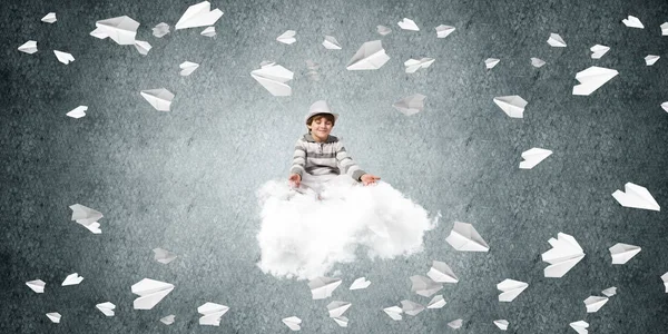 若い男の子の目を維持が閉じられ 雲の背景に灰色の暗い壁に紙飛行機を飛行中の飛行で瞑想しながら集中して見て — ストック写真