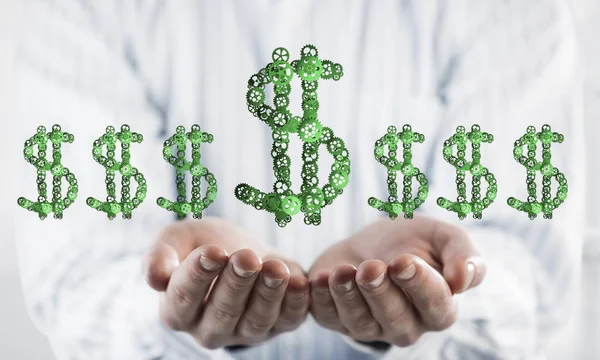 Close of businessman hand showing in palm gear made dollar sign