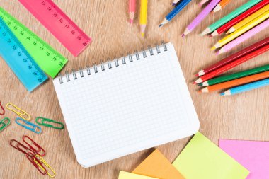 Ahşap masa blackground yaratıcılık kavram olarak üzerinde boş not defteri ve renk kalemler