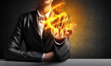 İşadamı ile arka plan üzerinde koyu duvar elinde yanan euro işareti gösteren takım elbiseli Close-up.