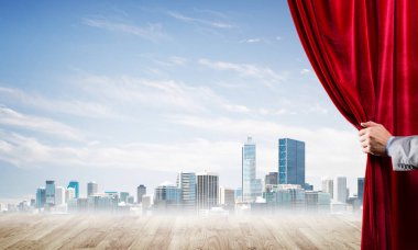 İnsan eli modern cityscape ve bulutlu gökyüzü kırmızı kadife perde açılır