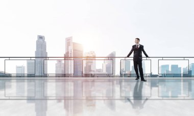 Gökdelenlerin üzerinde gün doğumu ve yeni bir güne bakan iş adamı