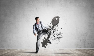 Boş iç mekandaki azimli iş adamı bacak tekmeleme taş figürü ile kırılıyor.