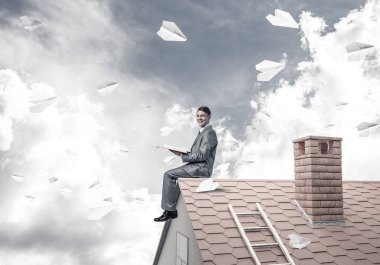 Elinde kırmızı kitap ile ev oturan genç işadamı