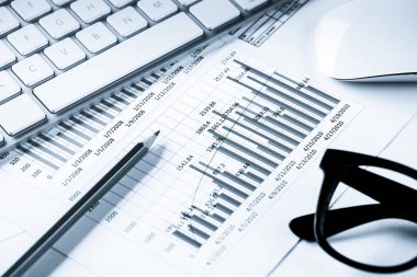 Klavye fareli iş yeri ve grafik ve diyagramlı kağıtlar