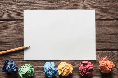 Tahta masadaki beyaz kağıt ve kalemi kapat.