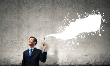 Arka planda gri koyu duvara karşı beyaz müzikal sıçrama ile siyah takım elbise ayakta başarılı ve güvenilir işadamı kavramsal görüntü.