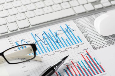 Klavye fareli iş yeri ve grafik ve diyagramlı kağıtlar