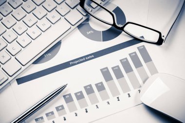 Klavye gözlüklü ve mali belgeleri masada olan iş yeri