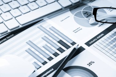 Klavye fareli iş yeri ve grafik ve diyagramlı kağıtlar