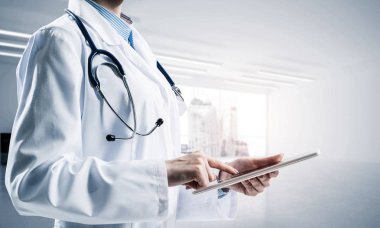 Başarılı kadın doktorun parmak duran beyaz hastane binasının kapalı tabletiyle dokunmadan kapatın. Tıp sektöründe kavramı kendine güvenen doktor aracılığıyla
