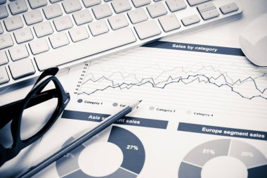 Klavye gözlüklü ve mali belgeleri masada olan iş yeri