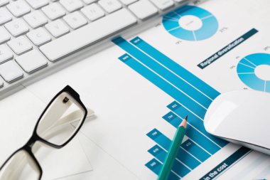 Klavye fareli iş yeri ve grafik ve diyagramlı kağıtlar