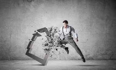 Kararlı iş adamı beton tekmeyle zıplıyor ve kırıyor.