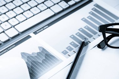 Klavye fareli iş yeri ve grafik ve diyagramlı kağıtlar