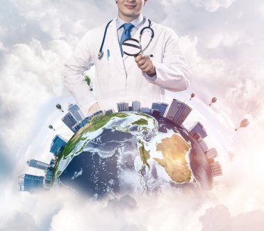 Kavramsal görüntü içinde beyaz Tıbbi üniforma Büyüteç aracılığıyla dünya dünya üzerinde arka plan üzerinde bulutlu gökyüzü ile seyir emin doktor. Tıp sektöründe kavramı. Nasa tarafından döşenmiş bu görüntü unsurları