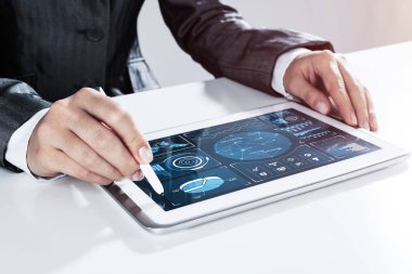 Masada oturan ve Stylus tableti ile dokunan bir iş kadını.