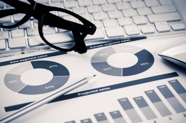 Klavye gözlüklü ve mali belgeleri masada olan iş yeri