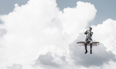 Genç kitap üzerinde oturan ve avuç içi gözlerle kapsayan bir işadamı şok