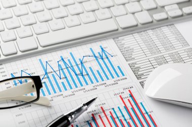 Klavye fareli iş yeri ve grafik ve diyagramlı kağıtlar
