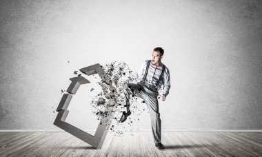 Kararlı iş adamı bacak tekmeleme beton figür ile zıplıyor ve kırıyor