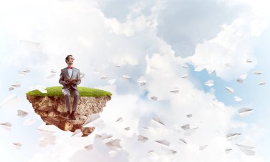 Komik adam kırmızı gözlük ve yeşil ada ve okuma kitabı üzerinde oturan takım elbise