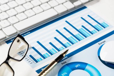 Klavye fareli iş yeri ve grafik ve diyagramlı kağıtlar