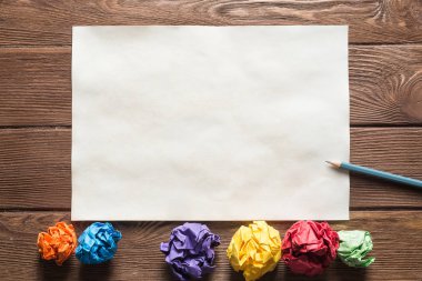 Tahta masadaki beyaz kağıt ve kalemi kapat.