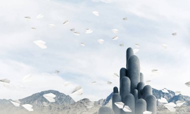 Açık havada, arka planda güzel manzarası olan uçan kağıt uçaklar arasında yer alan yüksek ve büyük taş sütunların resmi. Duvar kağıdı, telif alanı olan arkaplan.