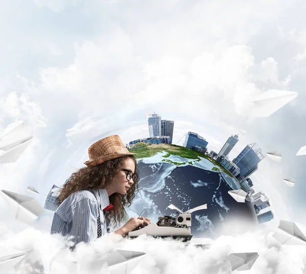 Portrait of woman writer looking away and using typing machine while sitting at the table with flying paper planes and Earth globe among cloudy skyscape on background. Elements of this image furnished by NASA