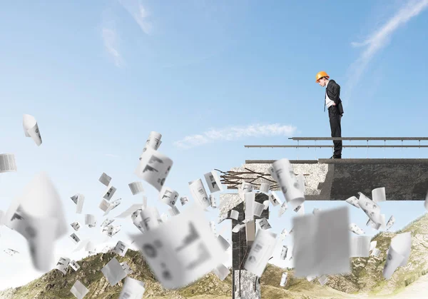 Giovane Ingegnere Tuta Casco Guardando Basso Mentre Piedi Tra Carte — Foto Stock