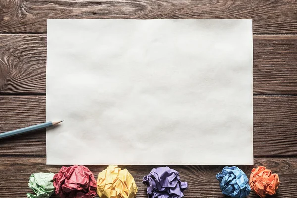 Tahta masadaki beyaz kağıt ve kalemi kapat.