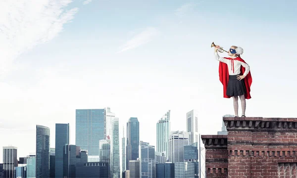建物の屋根の上に立ってスーパー ヒーローの衣装の少女 ミクスト メディア — ストック写真
