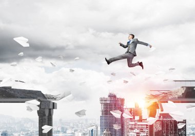 Kağıt uçaklar beton bridge uygulamasında zorlukların üstesinden sembolü olarak uçan ile gap üstünden atlayarak iş adamı. Cityscape zemin üzerine güneş ışığı ile. 3D render.