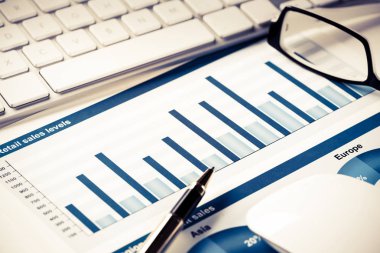 Klavye fareli iş yeri ve grafik ve diyagramlı kağıtlar