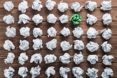 Fikir olarak ahşap masanın üzerine buruşmuş beyaz kağıt parçası.