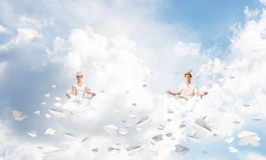 Genç çift gözleri koruma kapalı ve seyir kağıt uçaklar hava bulutlu gökyüzü ile arka plan üzerinde uçan arasında meditasyon sırasında konsantre.