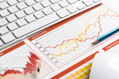 Klavye fareli iş yeri ve grafik ve diyagramlı kağıtlar