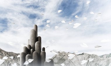 Açık havada, arka planda güzel manzarası olan uçan kağıt uçaklar arasında yer alan yüksek ve büyük taş sütunların resmi. Duvar kağıdı, telif alanı olan arkaplan.