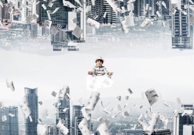 Genç çocuk gözleri kapalı ve bulut kağıtları uçan arasında ve kentsel dünyalar arasında üzerinde meditasyon sırasında konsantre seyir tutmak.