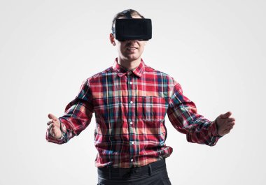 Ekose desenli gömlek gri arka plan karşı sanal kask giymiş genç adam