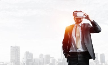 Genç yakışıklı iş adamı cityscape arka plan karşı sanal kask