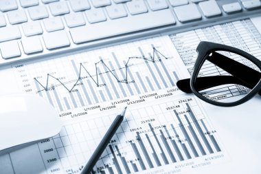 Klavye fareli iş yeri ve grafik ve diyagramlı kağıtlar