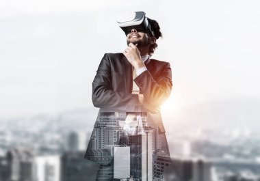 Genç yakışıklı iş adamı cityscape arka plan karşı sanal kask