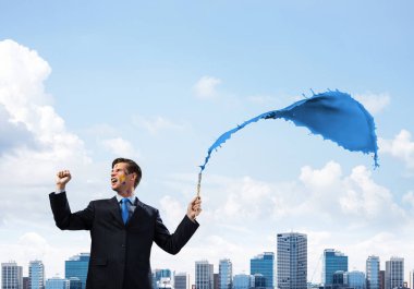 Neşeli ve genç işadamı mimik ve duran cityscape görünümü arka plan üzerinde karşı mavi renkli sıçrama ile gülümseyen siyah elbiseli yatay çekim.