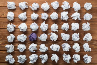 Fikir olarak ahşap masanın üzerine buruşmuş beyaz kağıt parçası.