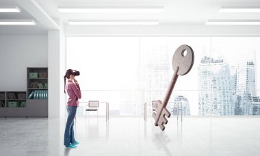 Sanal gerçeklik kasklı genç kadın taş anahtar sembolüne bakıyor. Karışık ortam