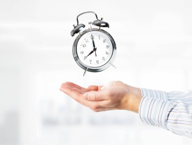 Çalar saat elinde tutan işadamı kapatın. Karışık teknik